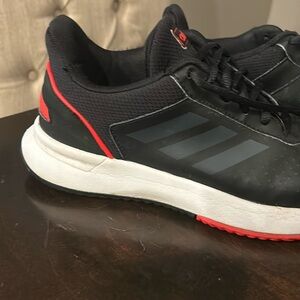 Adidas tennis shoes in black with red accent.